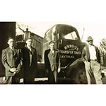 Cecil Boyd, at left, and his brothers Hilly and Dempsey, stand next to a tractor their father, William Nickey Boyd, right, operated. Following World War II, the Boyd brothers drove trucks for 10 years before starting their own company – Boyd Brothers in 1956. (Photo: Business Wire)
